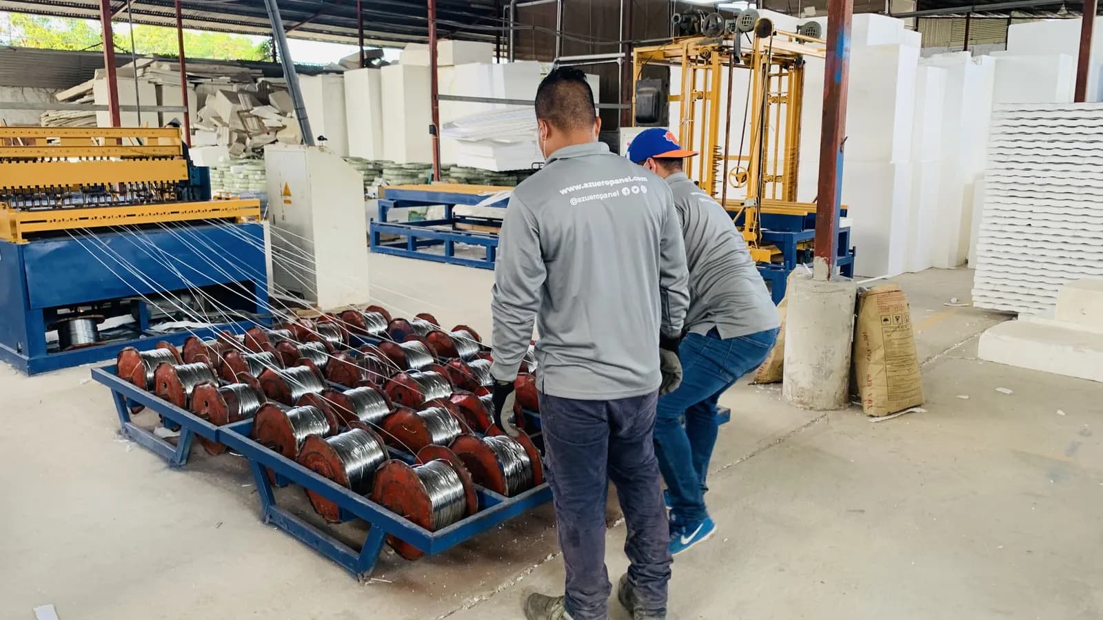 Operarios de Azuero Panel trasladando bobinas de alambre en la fábrica
